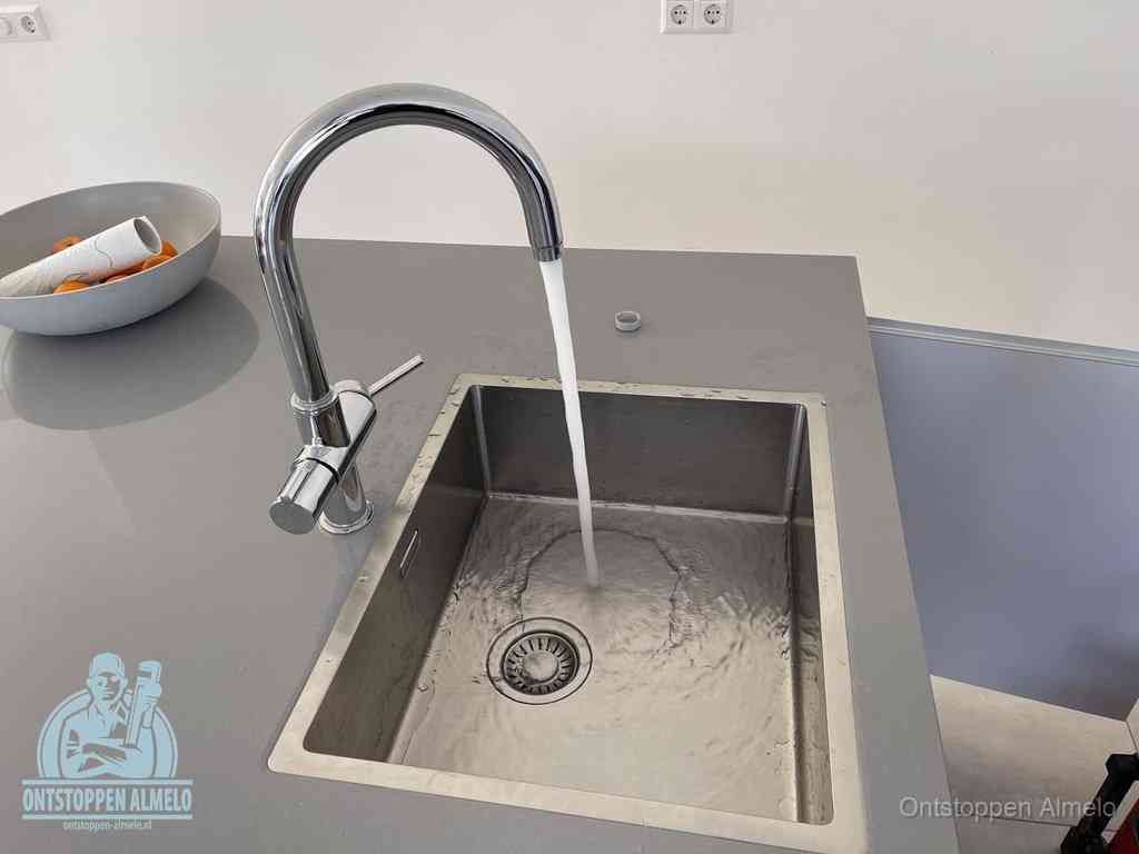 Een vrij doorstromende rvs spoelbak waar het water moeiteloos wegloopt, het resultaat van slim onderhoud dat geld bespaart in Almelo