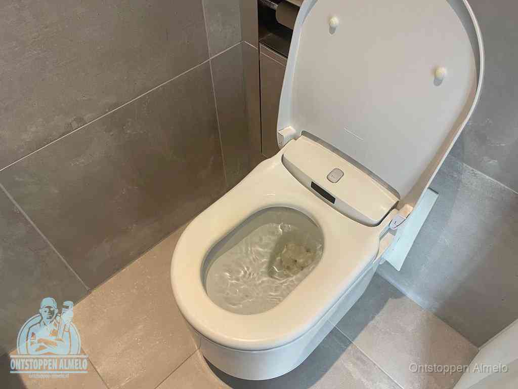 Een toiletpot vol troebel water met drijvend papier en restanten, de meest voorkomende oorzaak van een verstopte wc in Almelo