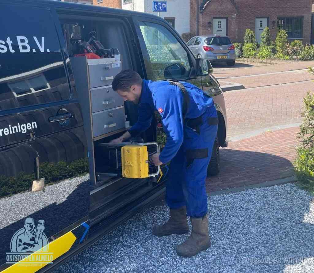 Een monteur pakt apparatuur uit de bedrijfsbus voor service aan huis, het moment om een professional in te schakelen in Almelo
