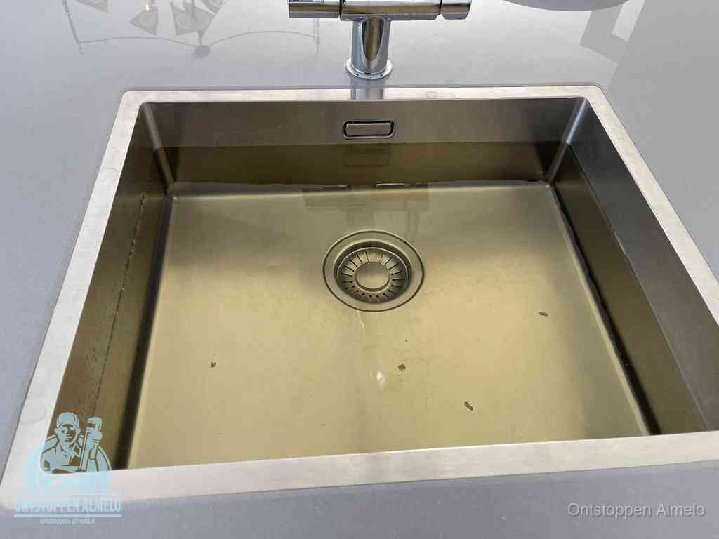 Stilstaand water in een rvs spoelbak dat niet wegloopt, een duidelijk signaal van een gootsteenverstopping in Almelo