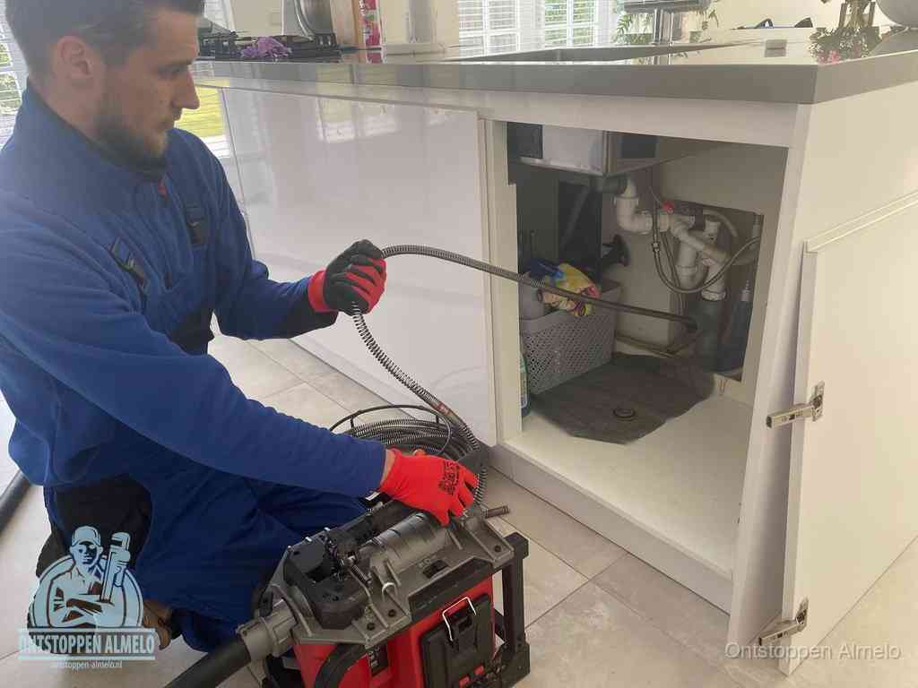 Een monteur reinigt de keukenafvoer grondig met een veermachine om terugkerende gootsteenverstoppingen te voorkomen in Almelo